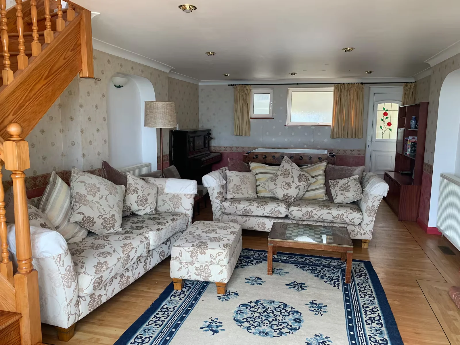Sunberry's spacious living room with piano and table football